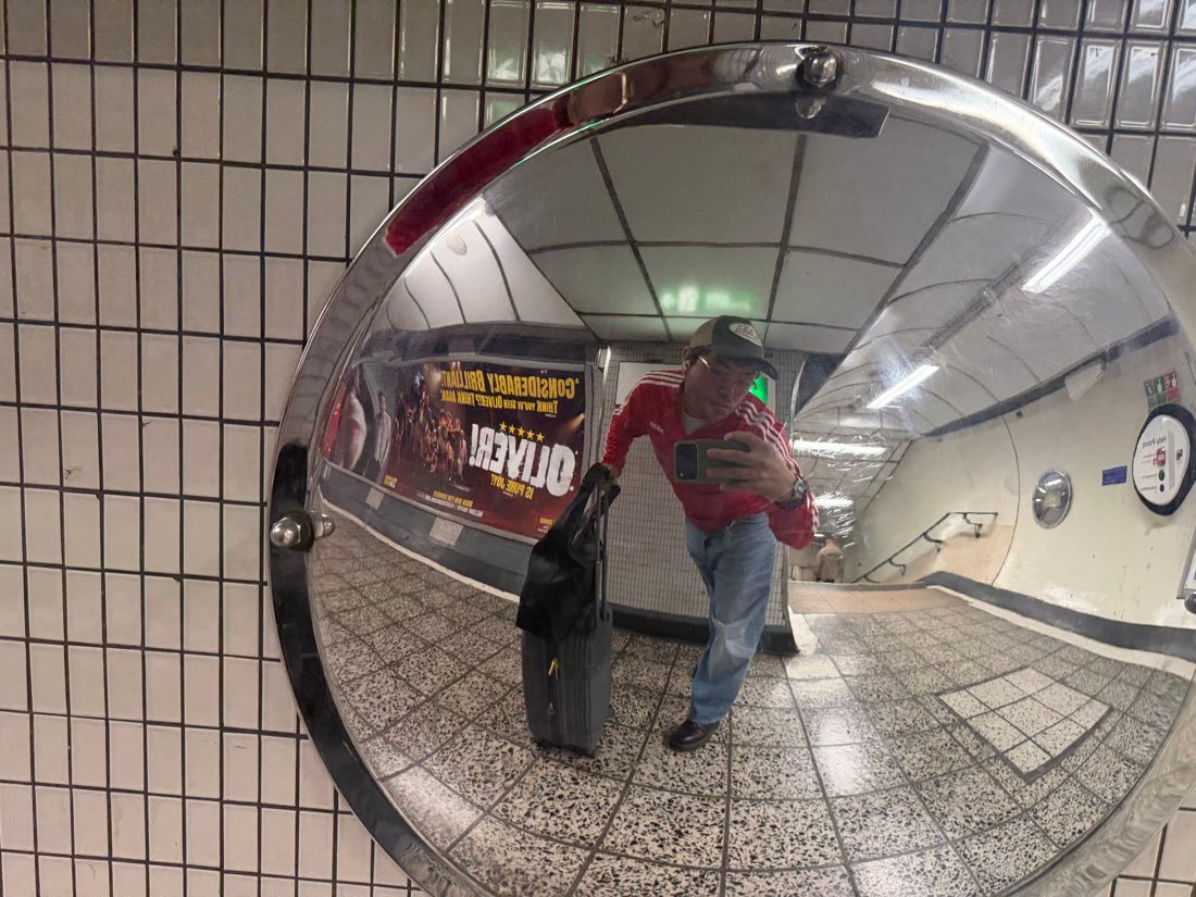 Sebastian filming himself in a convex station mirror