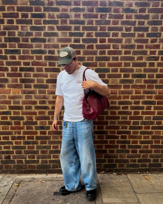 Sebastian walking past a London brick wall